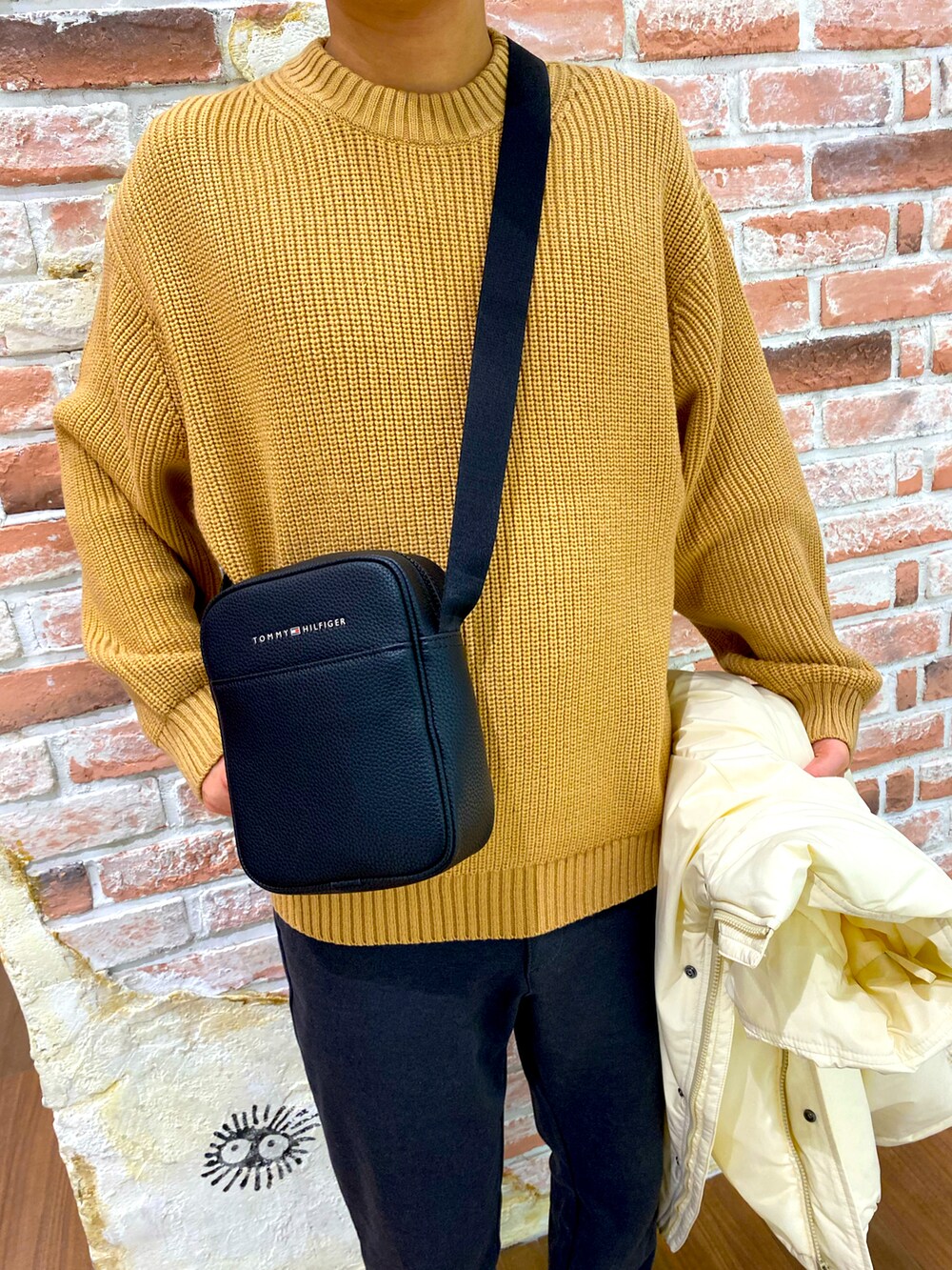 ブラック系のスニーカー、ブラック系のスウェットパンツ、ブラック系のショルダーバッグを着用したメンズの冬コーディネートの2枚目の写真