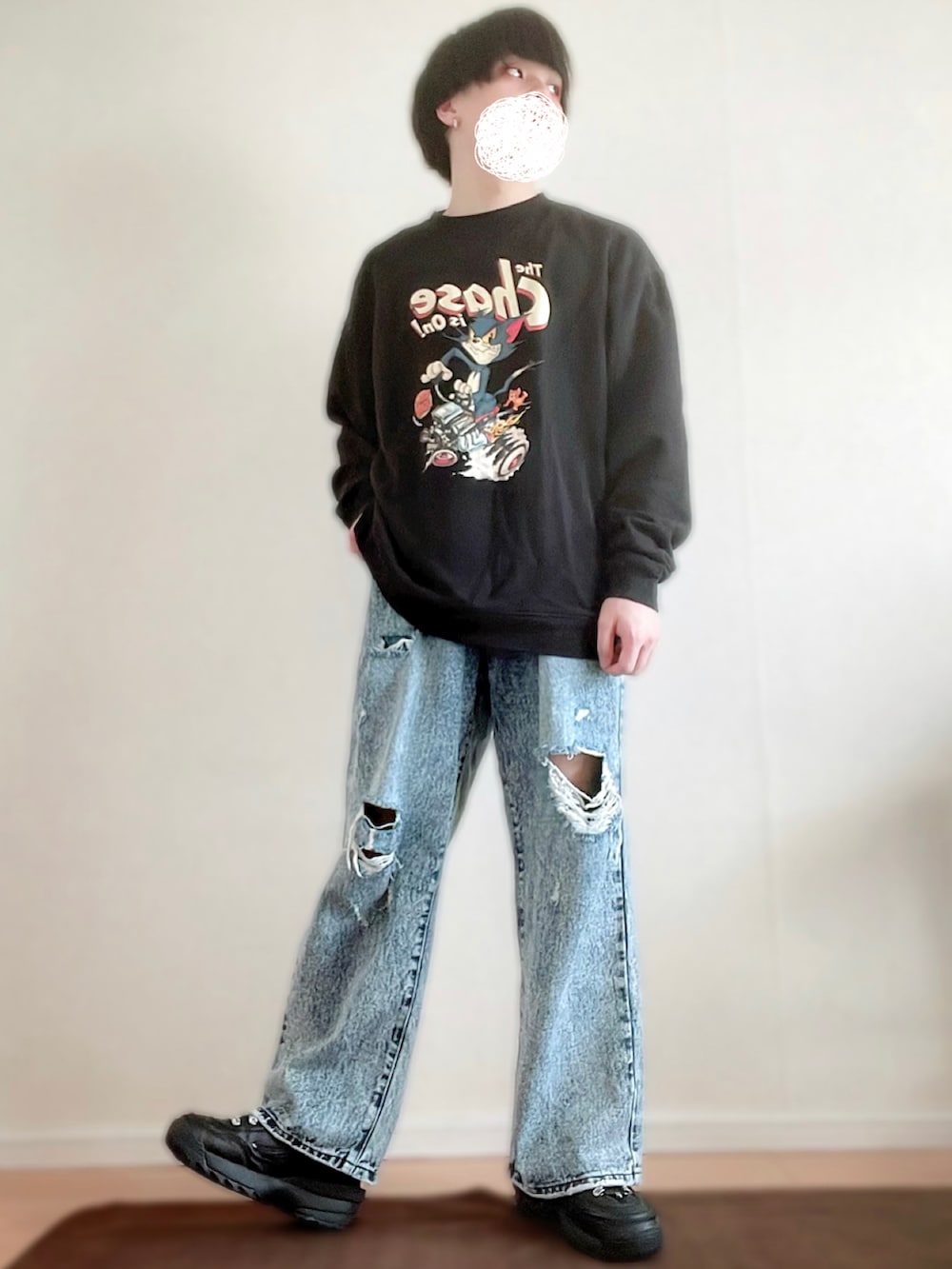 ブルー系のデニムパンツ、ブラック系のスウェット、ブラック系のスニーカーを着用したメンズの春コーディネートの2枚目の写真