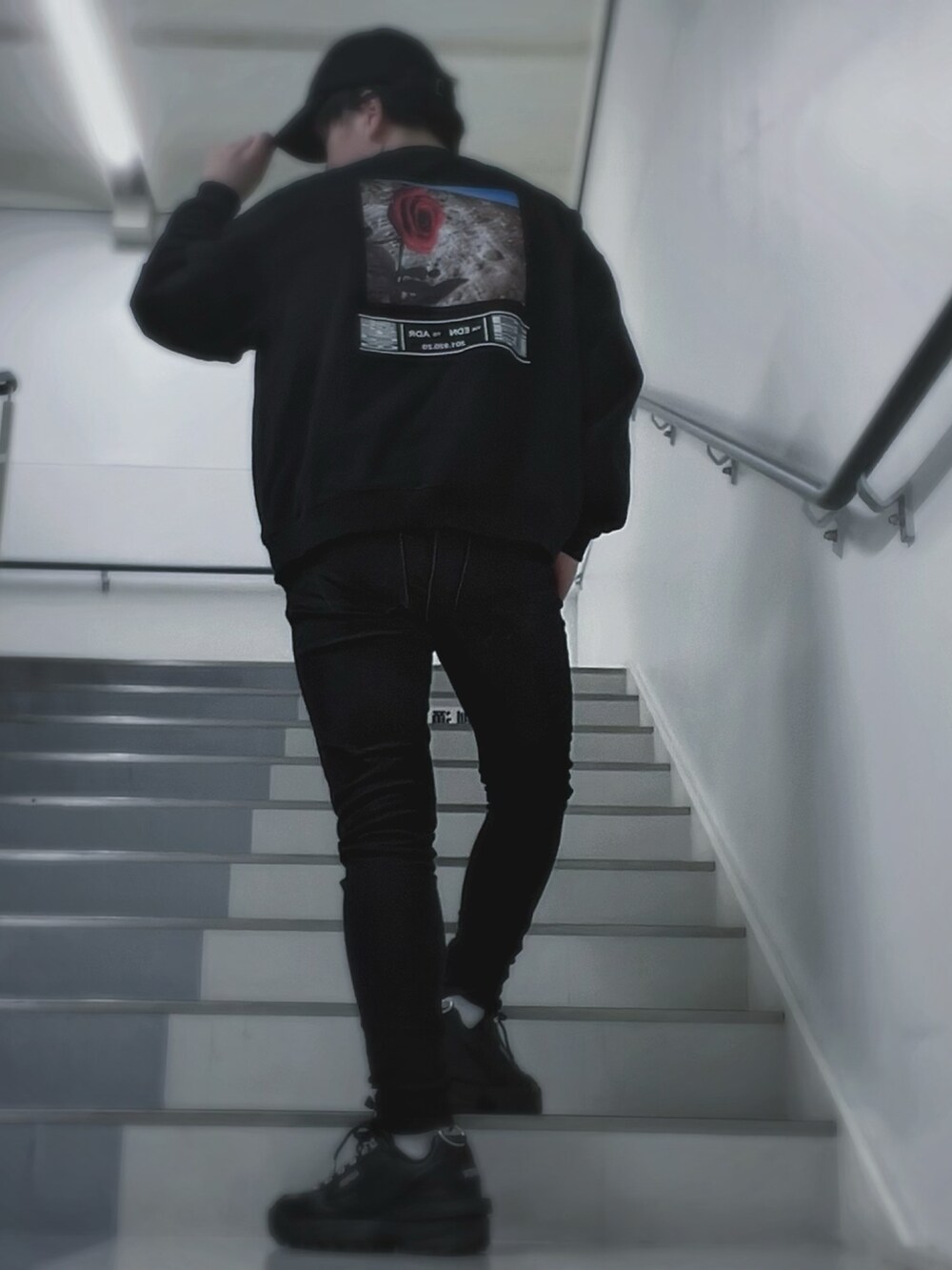 ブラック系のスウェット、ブラック系のデニムパンツ、ブラック系のスニーカーを着用したメンズの春コーディネートの2枚目の写真