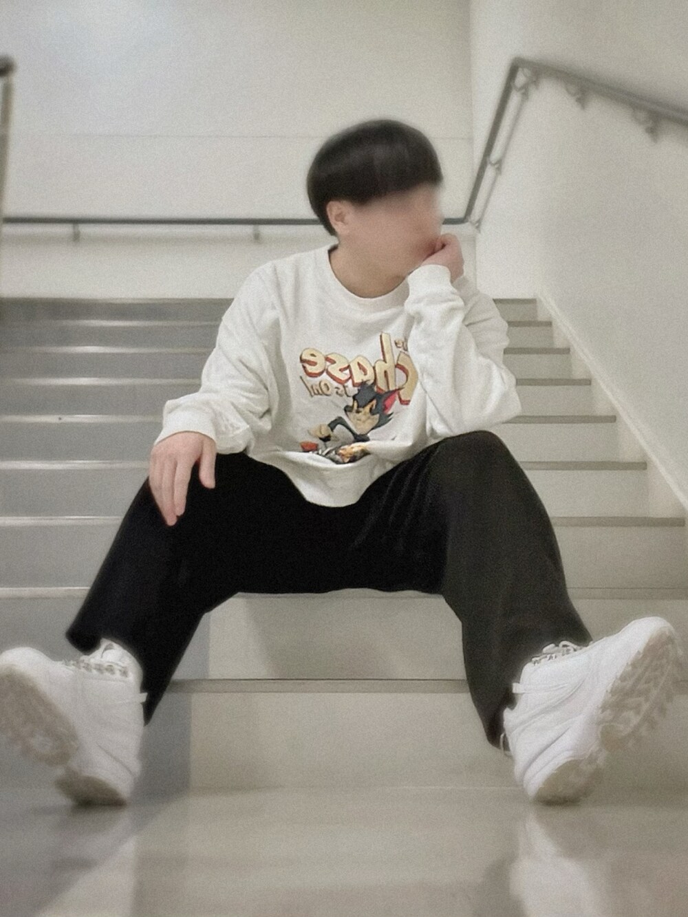 ホワイト系のスウェット、ブラック系のスラックス、ホワイト系のスニーカーを着用したメンズの冬コーディネートの2枚目の写真