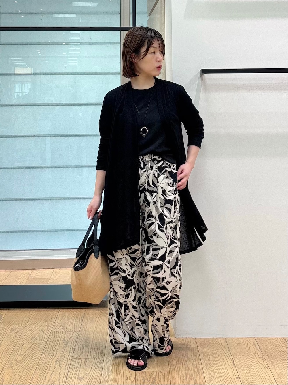 ブラック系のシャツ/ブラウス、ブラック系のその他パンツ、ベージュ系のトートバッグを着用したレディースの夏コーディネートの2枚目の写真