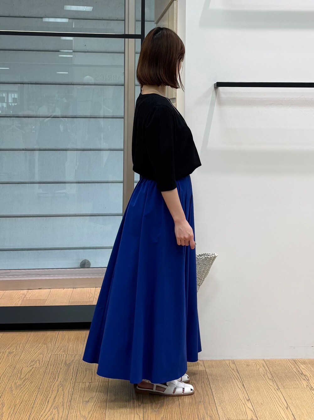 グレー系のカーディガン/ボレロ、ホワイト系のトートバッグ、ブルー系のスカートを着用したレディースの春コーディネートの9枚目の写真