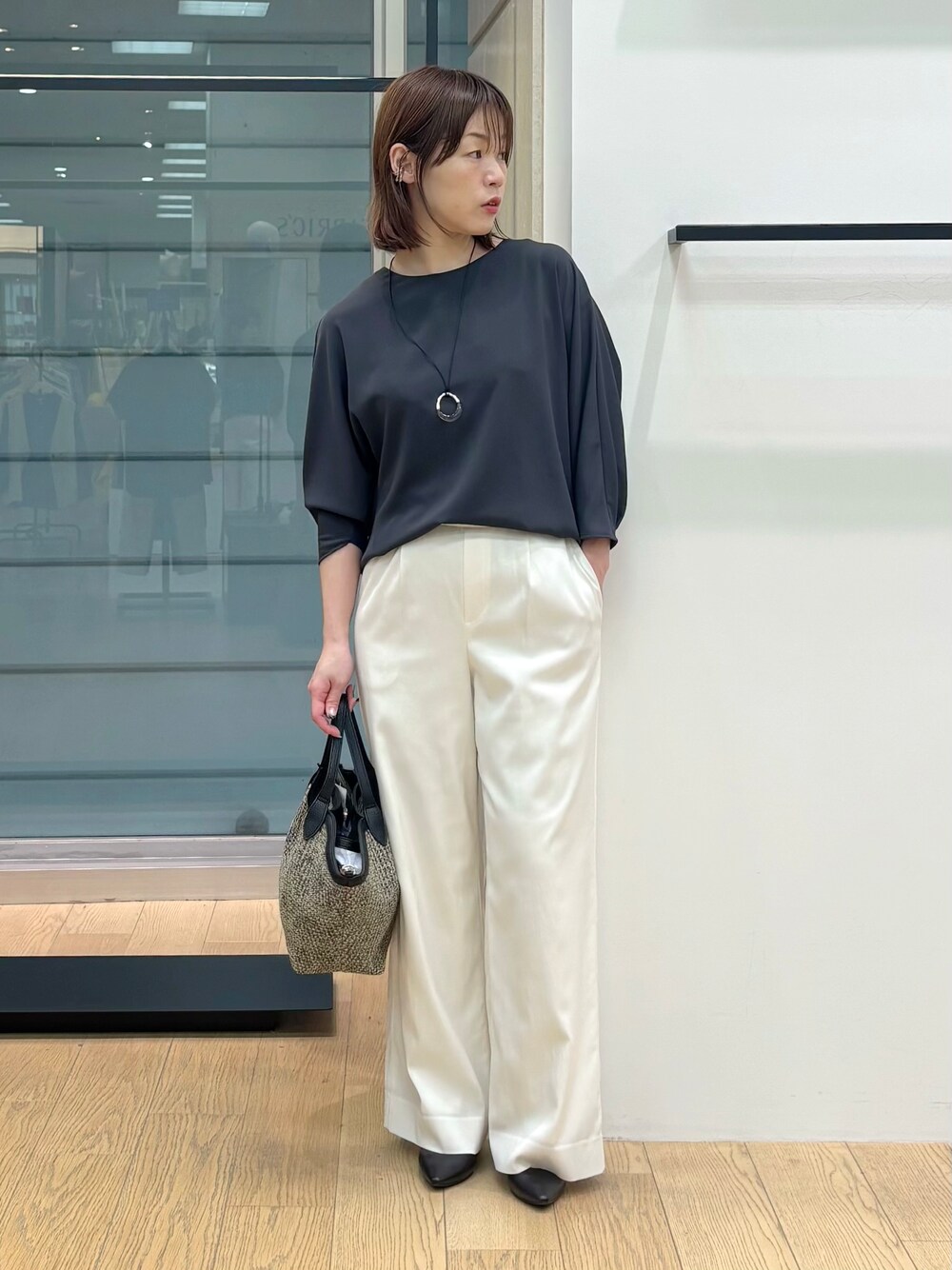 グレー系のシャツ/ブラウス、ホワイト系のその他パンツ、ブラック系のトートバッグを着用したレディースの春コーディネートの2枚目の写真