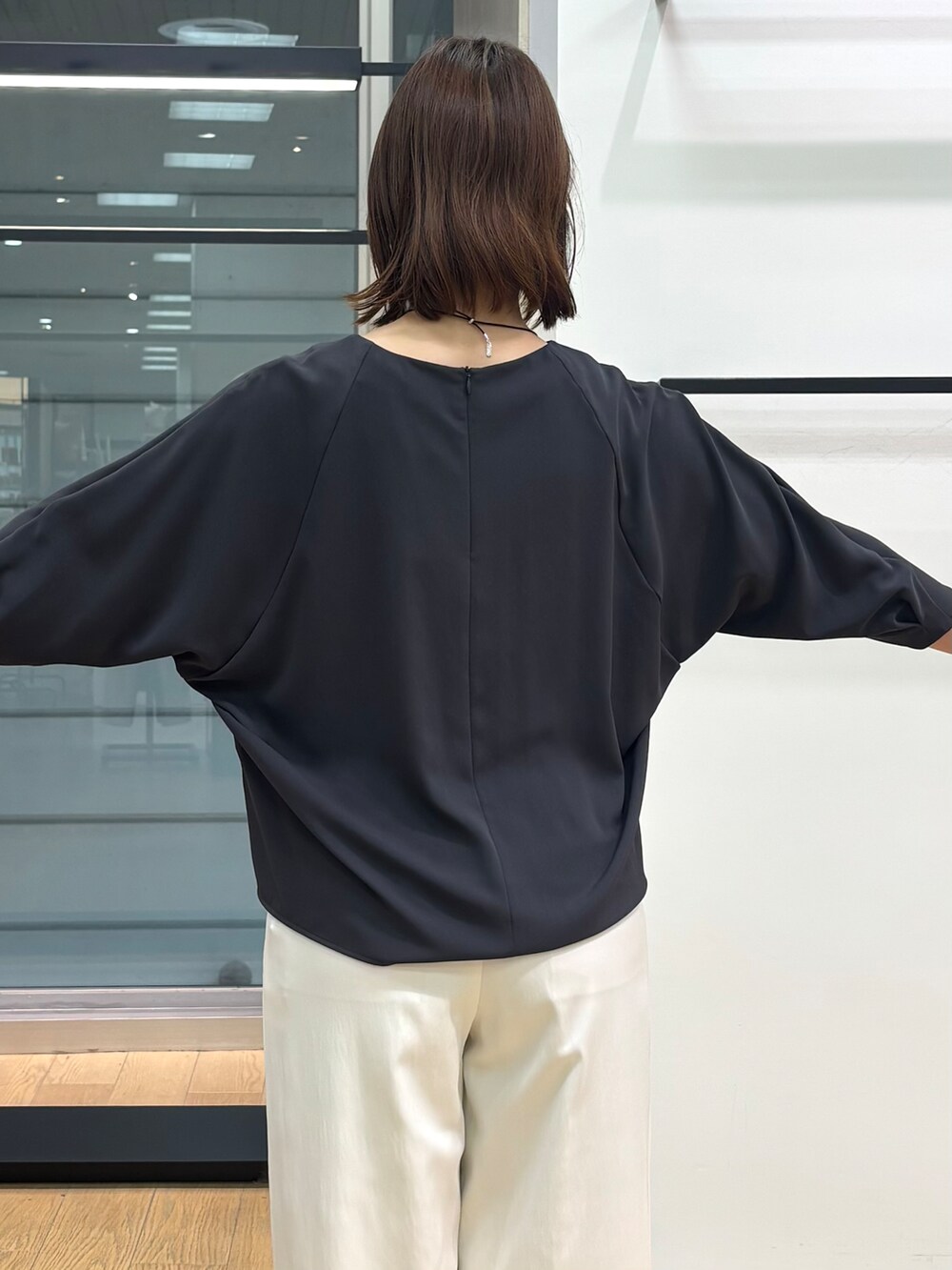 グレー系のシャツ/ブラウス、ホワイト系のその他パンツ、ブラック系のトートバッグを着用したレディースの春コーディネートの8枚目の写真
