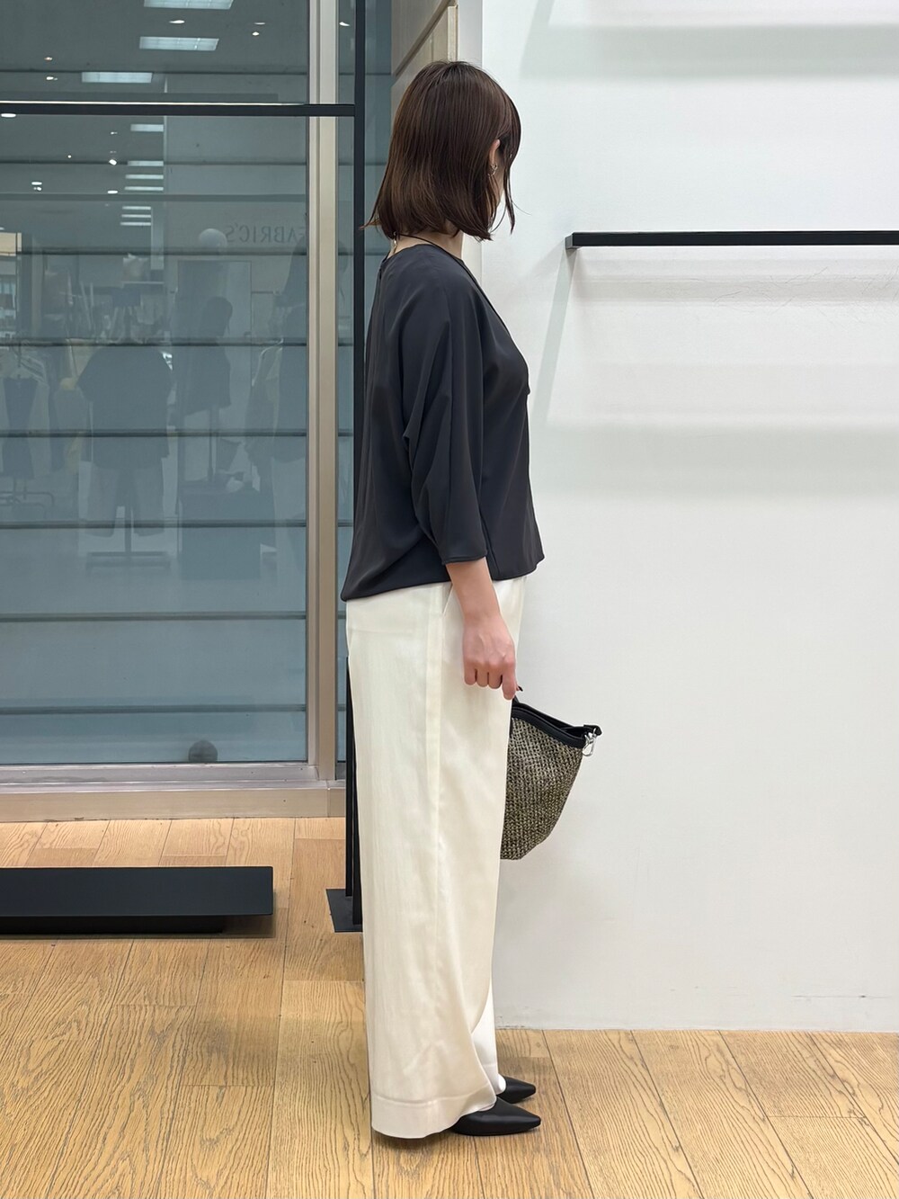 グレー系のシャツ/ブラウス、ホワイト系のその他パンツ、ブラック系のトートバッグを着用したレディースの春コーディネートの5枚目の写真