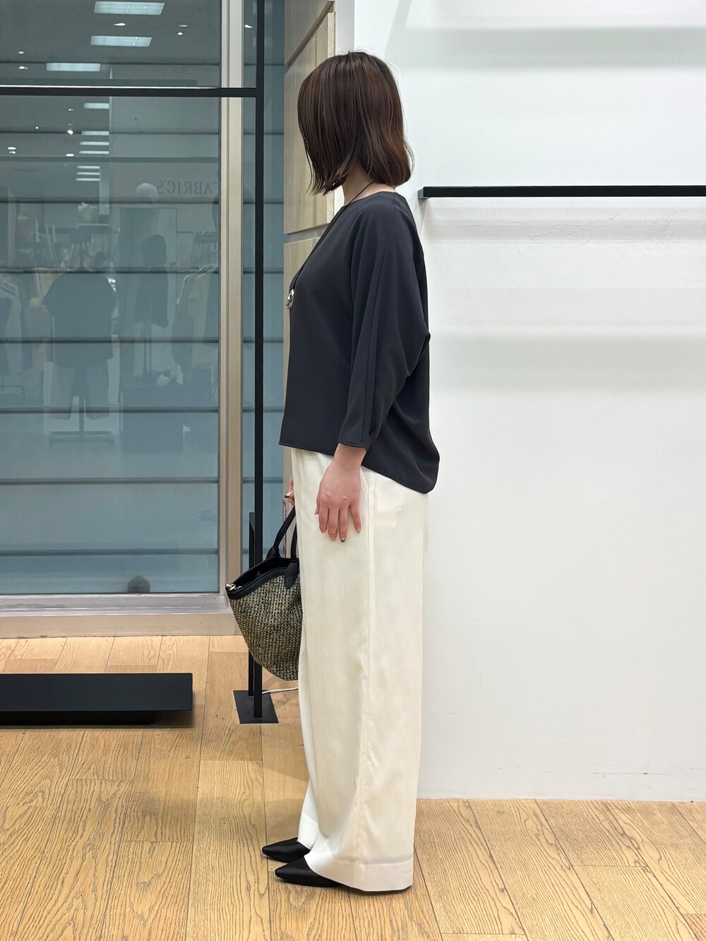 グレー系のシャツ/ブラウス、ホワイト系のその他パンツ、ブラック系のトートバッグを着用したレディースの春コーディネートの3枚目の写真