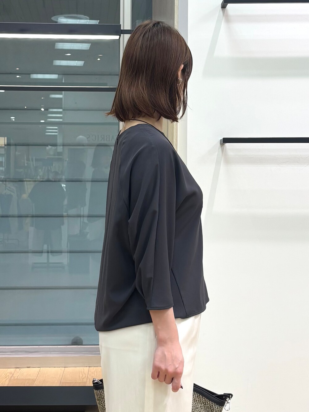 グレー系のシャツ/ブラウス、ホワイト系のその他パンツ、ブラック系のトートバッグを着用したレディースの春コーディネートの7枚目の写真