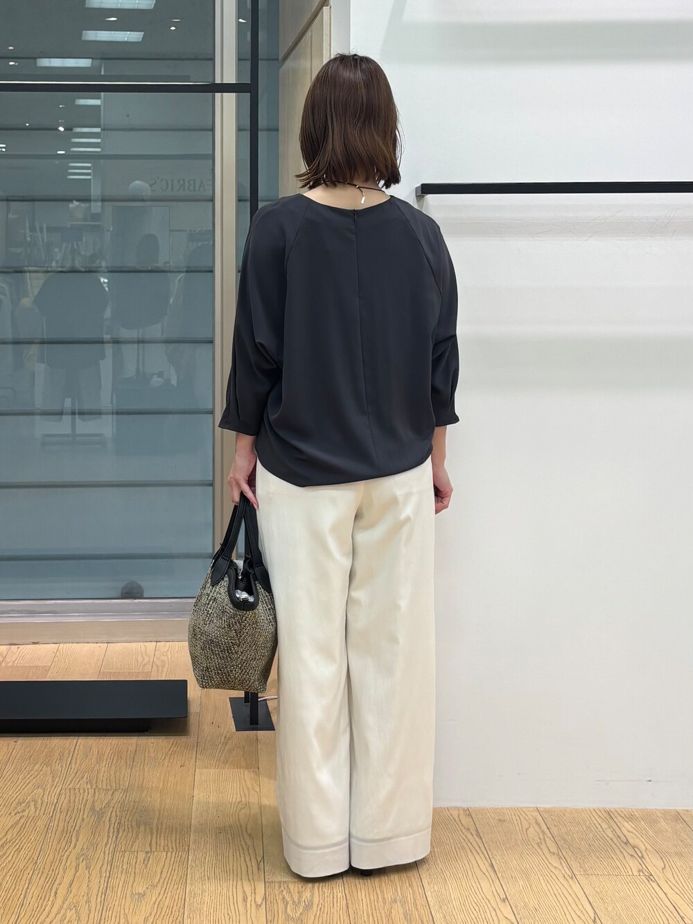 グレー系のシャツ/ブラウス、ホワイト系のその他パンツ、ブラック系のトートバッグを着用したレディースの春コーディネートの4枚目の写真