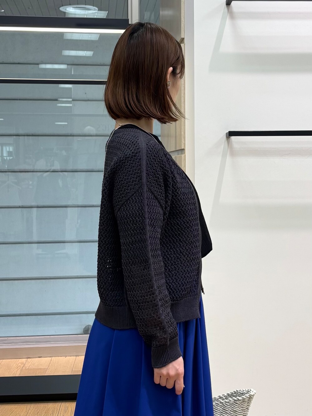 グレー系のカーディガン/ボレロ、ホワイト系のトートバッグ、ブルー系のスカートを着用したレディースの春コーディネートの6枚目の写真