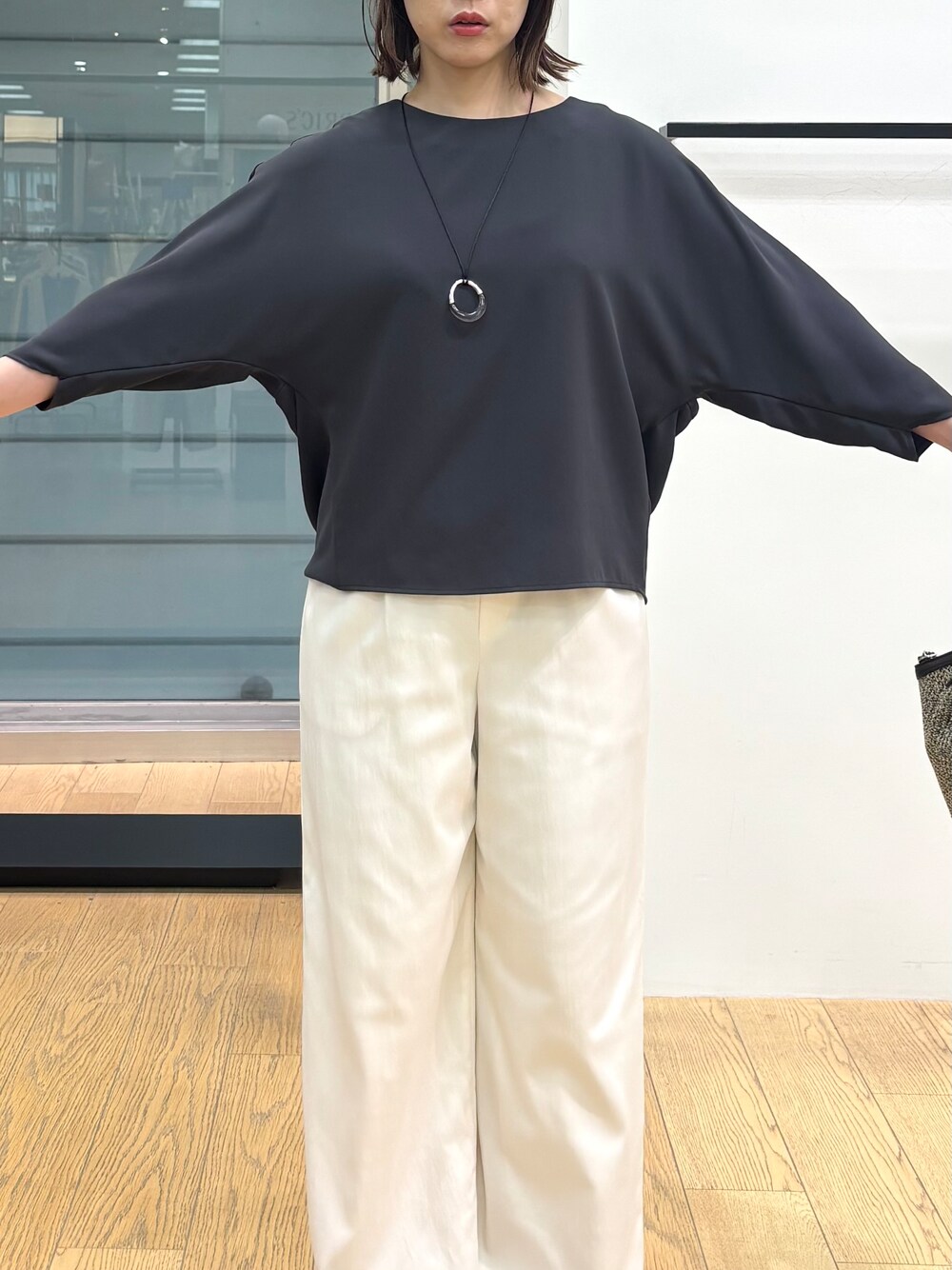 グレー系のシャツ/ブラウス、ホワイト系のその他パンツ、ブラック系のトートバッグを着用したレディースの春コーディネートの6枚目の写真