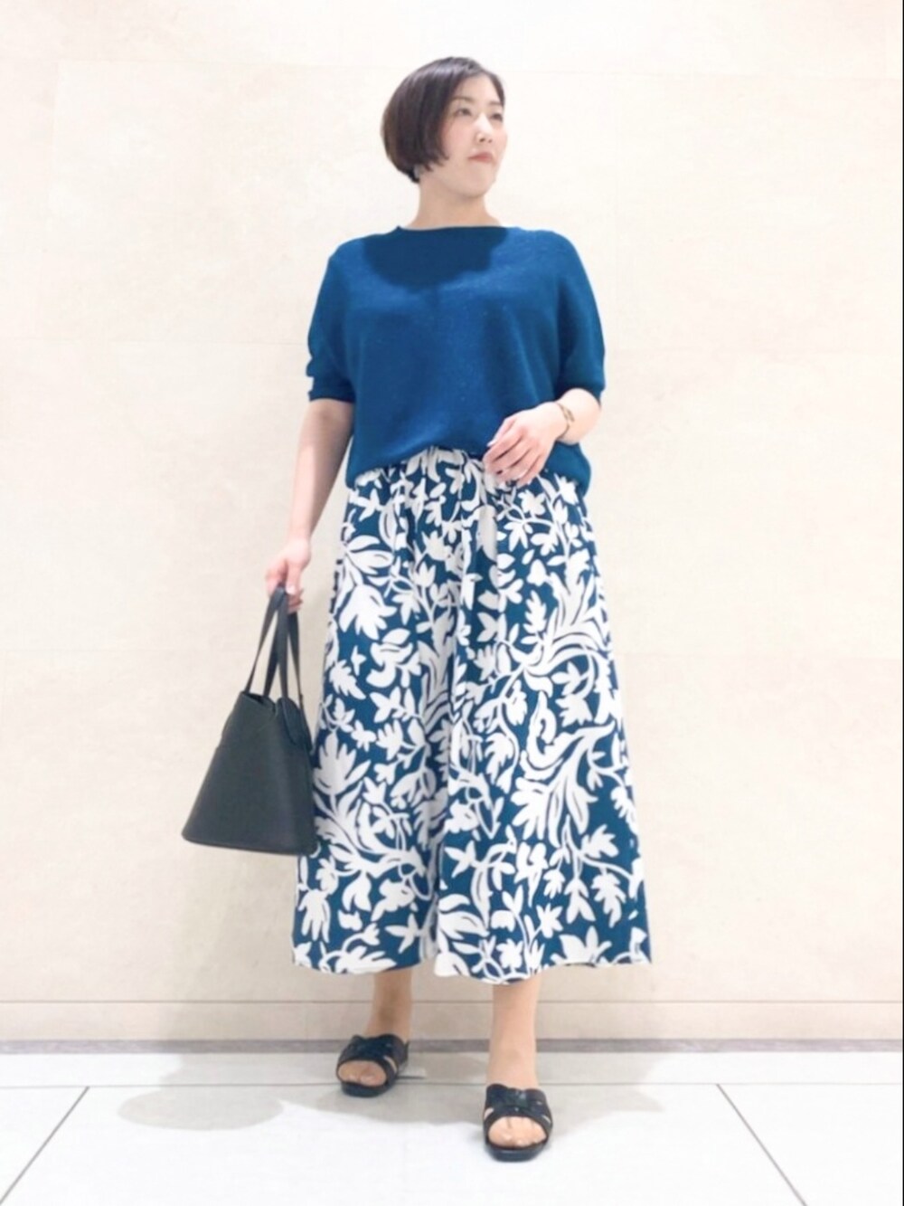 ホワイト系のブルゾン、グリーン系のニット/セーター、グリーン系のスカートを着用したレディースの夏コーディネートの2枚目の写真