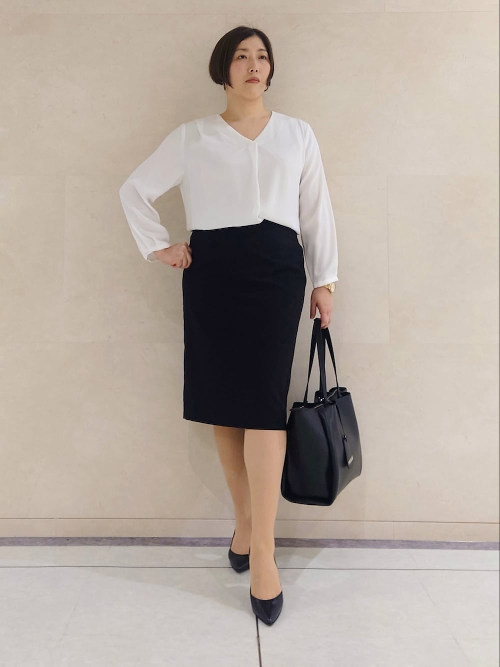 ブラック系のテーラードジャケット、ホワイト系のシャツ/ブラウス、ブラック系のトートバッグを着用したレディースの春コーディネートの2枚目の写真