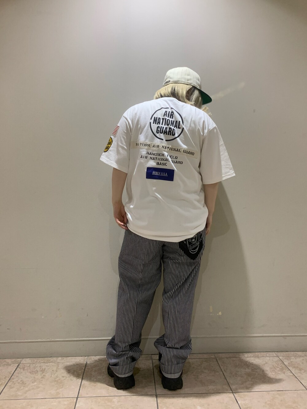 ホワイト系のTシャツ/カットソー、その他のチノパンツ、ホワイト系のキャップを着用したレディースの春コーディネートの2枚目の写真