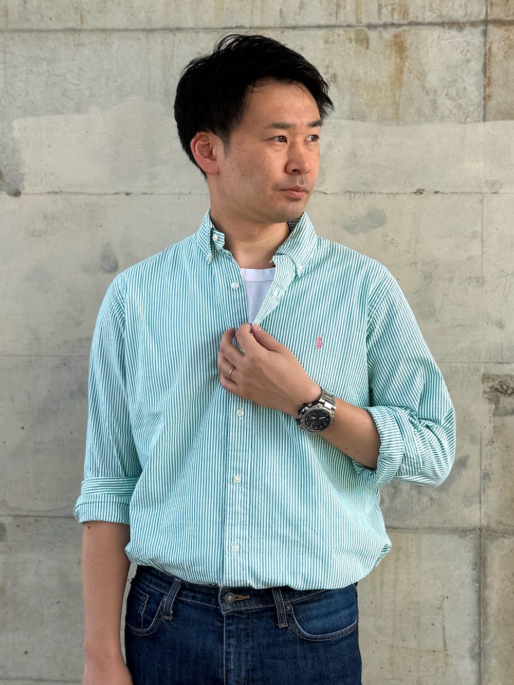 グリーン系のシャツ/ブラウス、ブルー系のデニムパンツ、ベージュ系のバックパック/リュックを着用したメンズの夏コーディネートの2枚目の写真