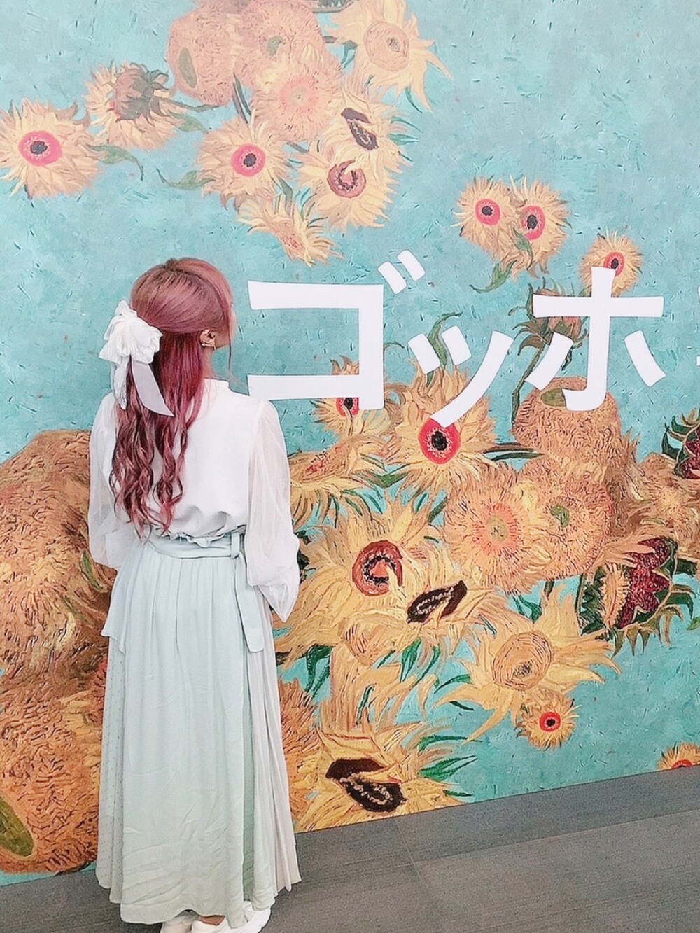 グリーン系のスカート、ホワイト系のスニーカー、ホワイト系のTシャツ/カットソーを着用したレディースの春コーディネートの2枚目の写真