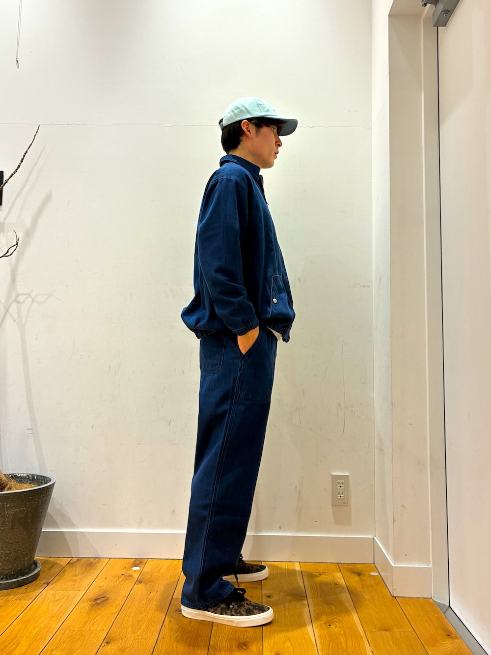 ブルー系のデニムジャケット、ブルー系のデニムパンツ、ブラウン系のスニーカーを着用したメンズの春コーディネートの3枚目の写真