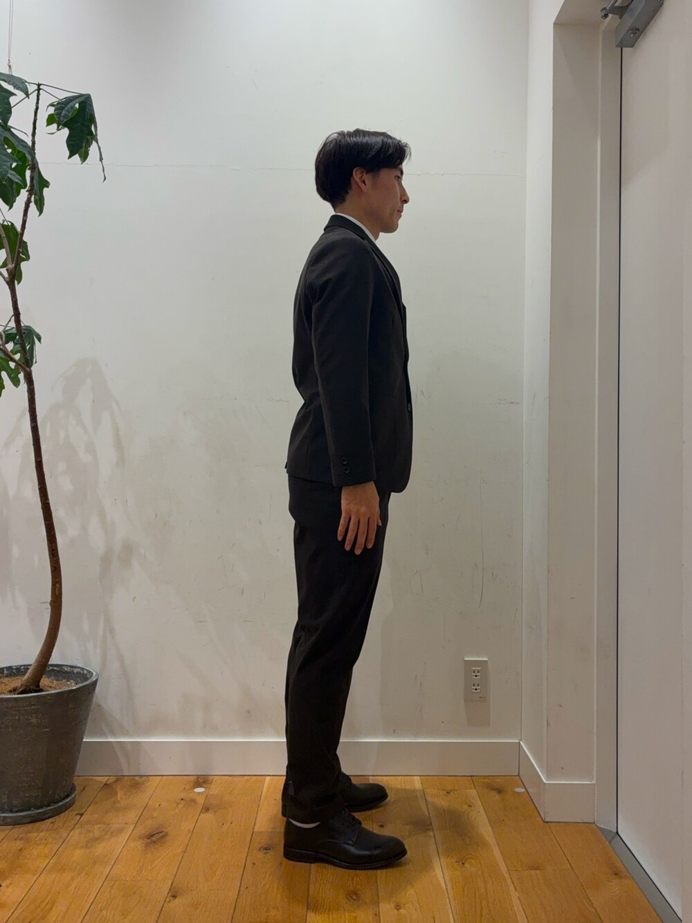 ブラウン系のスーツパンツ、ブルー系のその他アウター、ホワイト系のシャツ/ブラウスを着用したメンズの秋コーディネートの5枚目の写真