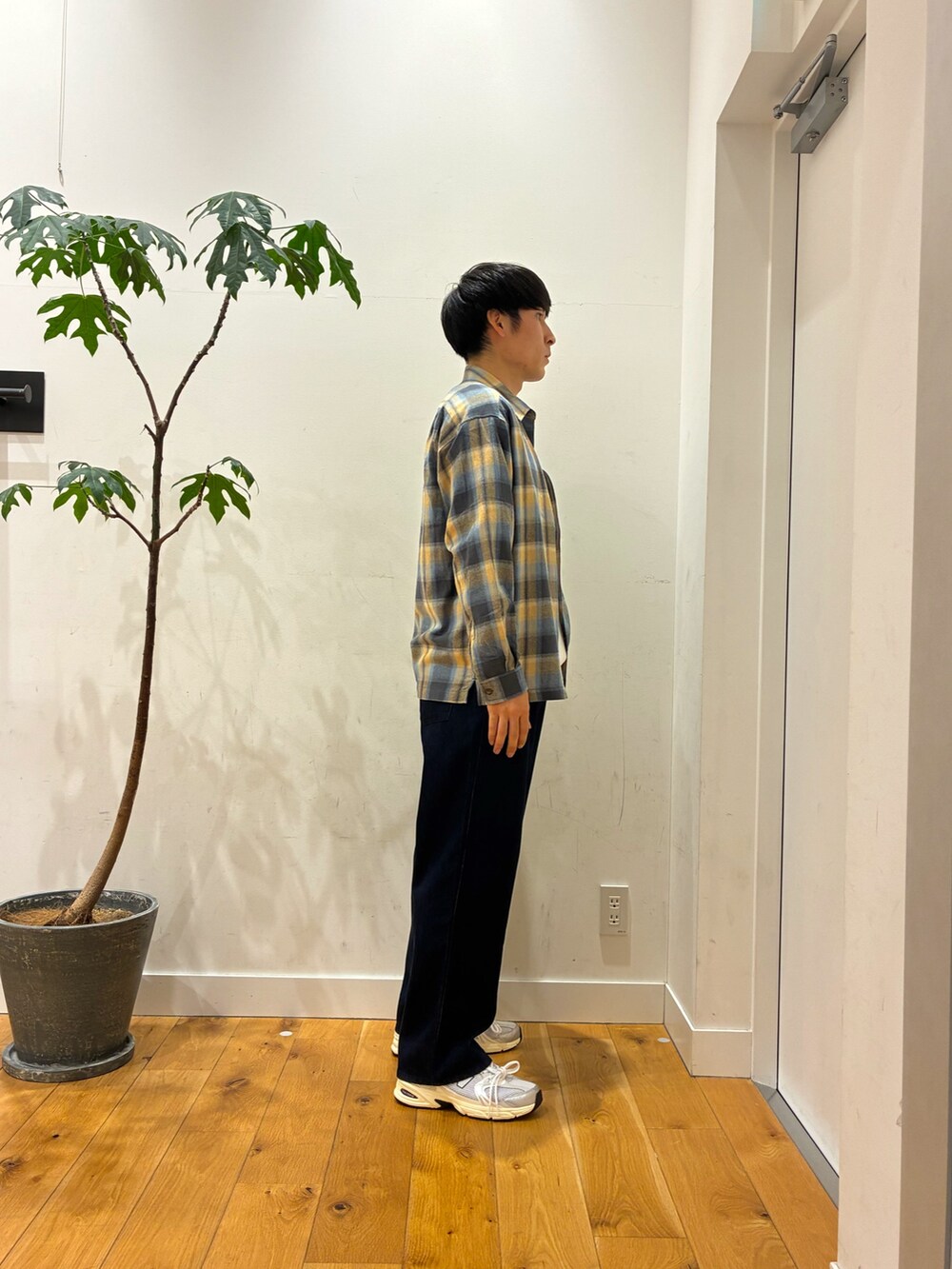 シルバー系のスニーカー、ブルー系のデニムパンツ、ホワイト系のTシャツ/カットソーを着用したメンズの秋コーディネートの3枚目の写真