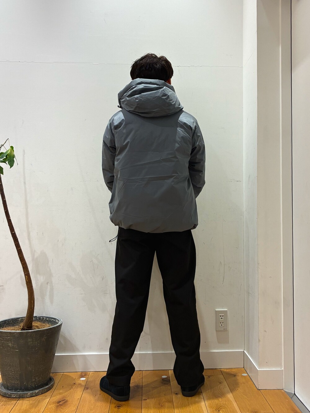 グレー系のダウンジャケット/コート、ブラック系のその他パンツ、ホワイト系のTシャツ/カットソーを着用したメンズの冬コーディネートの4枚目の写真