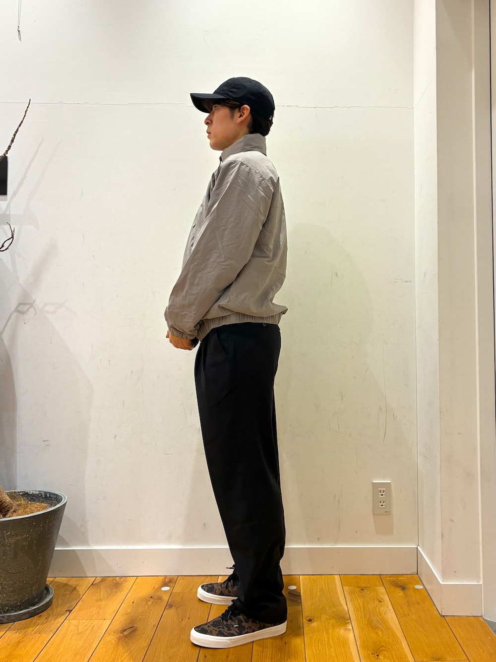 ブラック系のその他パンツ、ブラウン系のスニーカー、グレー系のニット/セーターを着用したメンズの春コーディネートの4枚目の写真