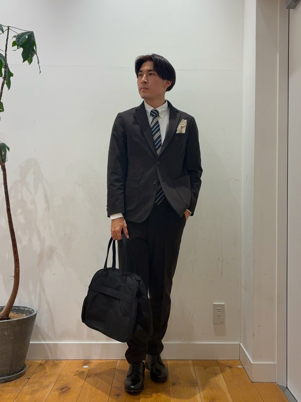 ブラウン系のスーツパンツ、ブルー系のその他アウター、ホワイト系のシャツ/ブラウスを着用したメンズの秋コーディネートの2枚目の写真