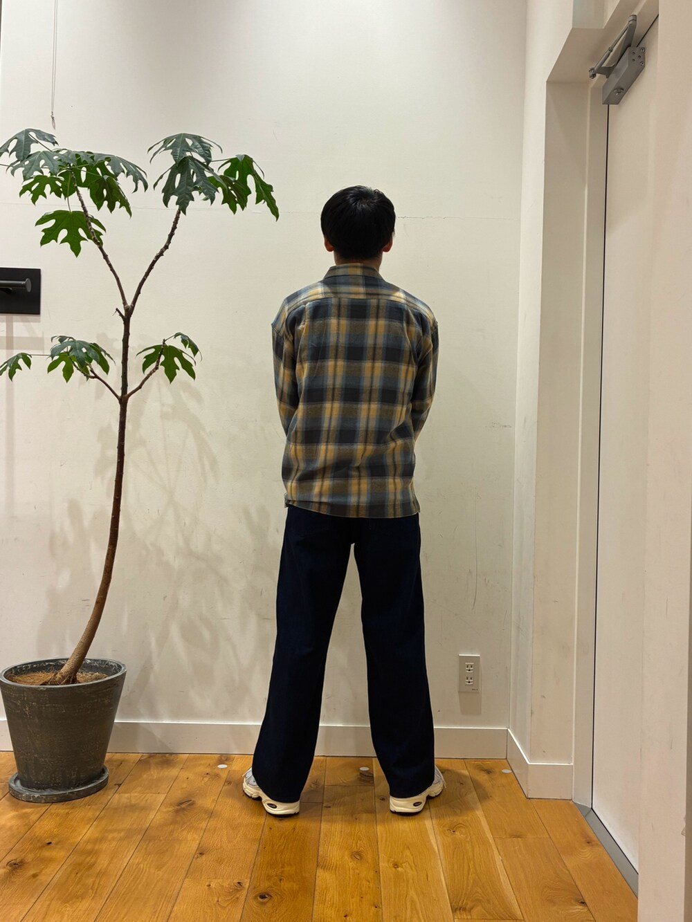 シルバー系のスニーカー、ブルー系のデニムパンツ、ホワイト系のTシャツ/カットソーを着用したメンズの秋コーディネートの4枚目の写真