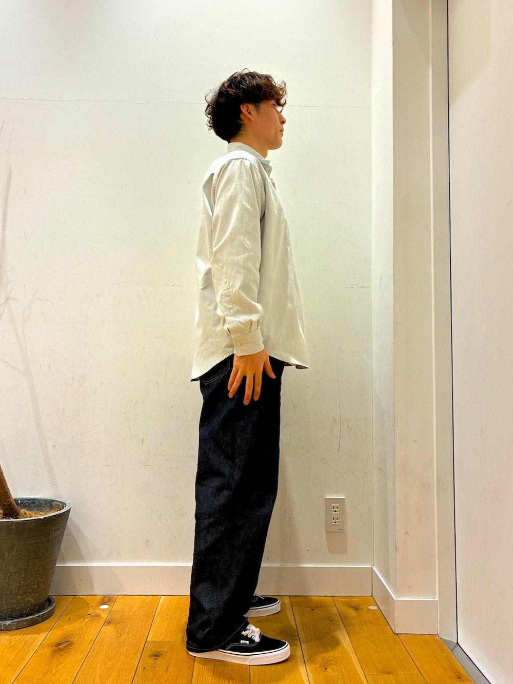 ブルー系のデニムパンツ、グレー系のシャツ/ブラウス、ブラック系のスニーカーを着用したメンズの春コーディネートの2枚目の写真