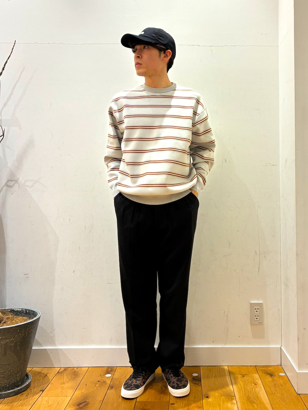 ブラック系のその他パンツ、ブラウン系のスニーカー、グレー系のニット/セーターを着用したメンズの春コーディネートの3枚目の写真