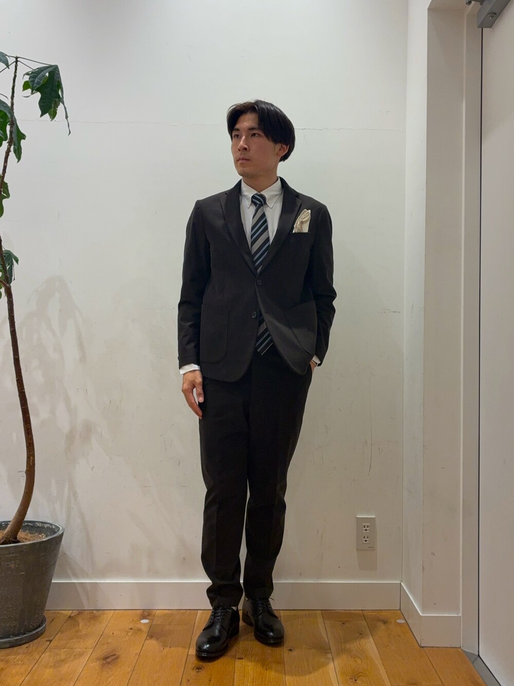 ブラウン系のスーツパンツ、ブルー系のその他アウター、ホワイト系のシャツ/ブラウスを着用したメンズの秋コーディネートの3枚目の写真