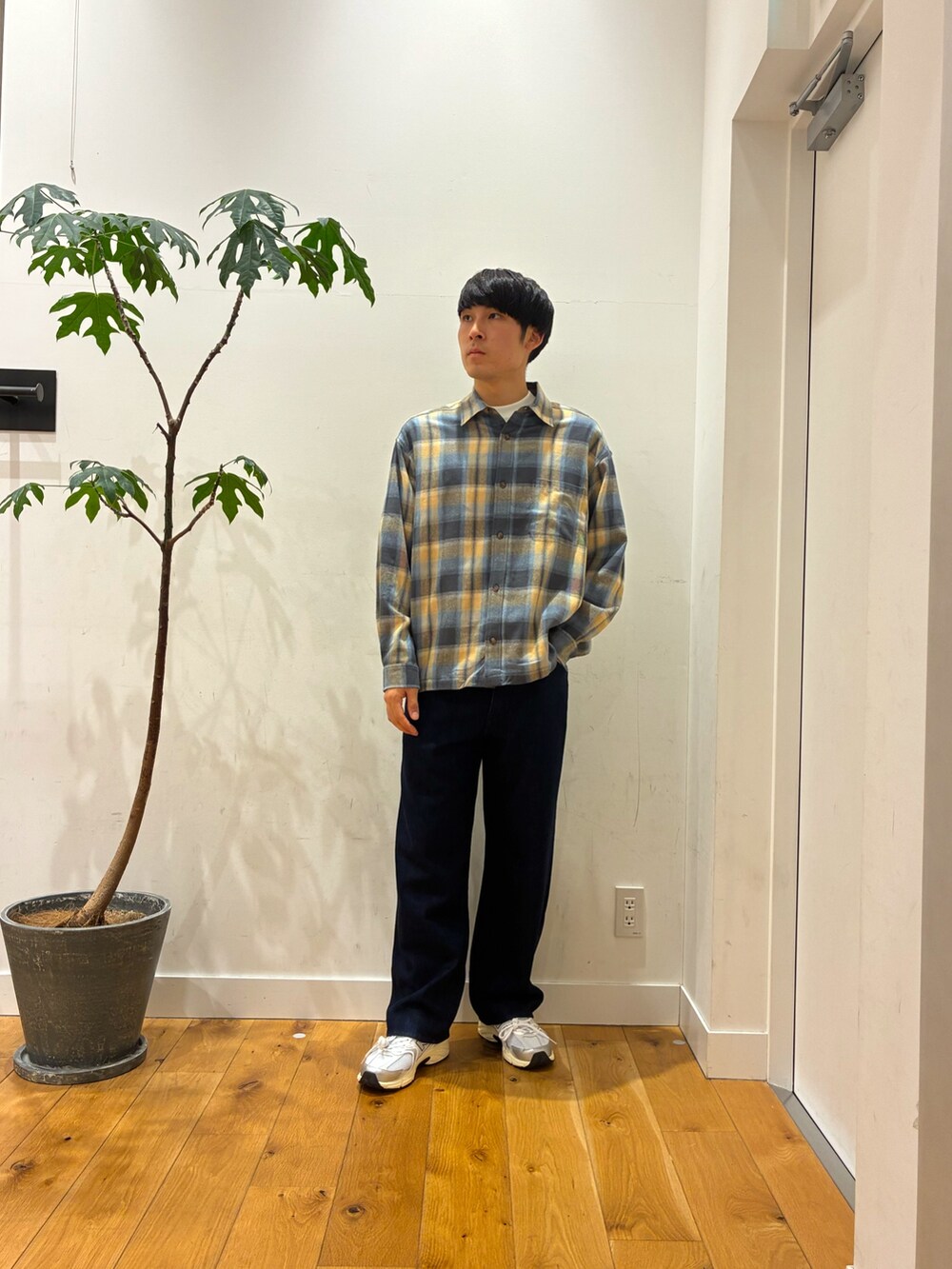 シルバー系のスニーカー、ブルー系のデニムパンツ、ホワイト系のTシャツ/カットソーを着用したメンズの秋コーディネートの2枚目の写真