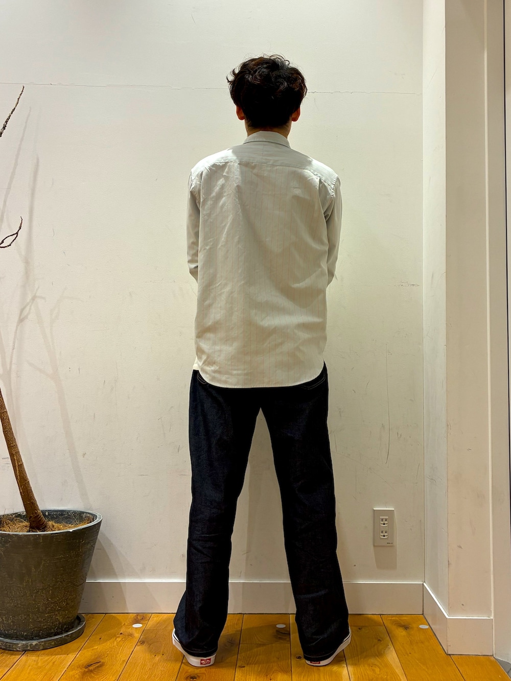 ブルー系のデニムパンツ、グレー系のシャツ/ブラウス、ブラック系のスニーカーを着用したメンズの春コーディネートの3枚目の写真