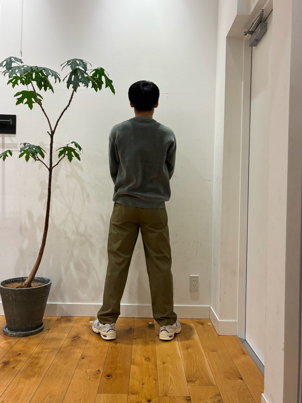 ベージュ系のその他パンツ、シルバー系のスニーカー、グリーン系のニット/セーターを着用したメンズの秋コーディネートの4枚目の写真