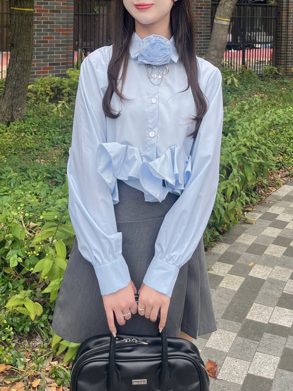 ブルー系のシャツ/ブラウス、グレー系のスカート、ブラック系のボストンバッグを着用したレディースの秋コーディネートの3枚目の写真