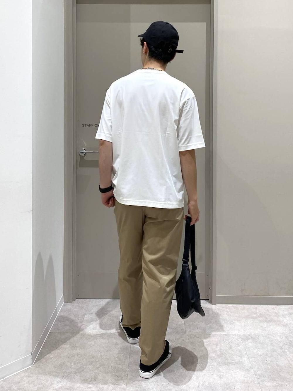 ベージュ系のその他パンツ、ホワイト系のTシャツ/カットソー、ブラック系のスニーカーを着用したメンズの夏コーディネートの3枚目の写真