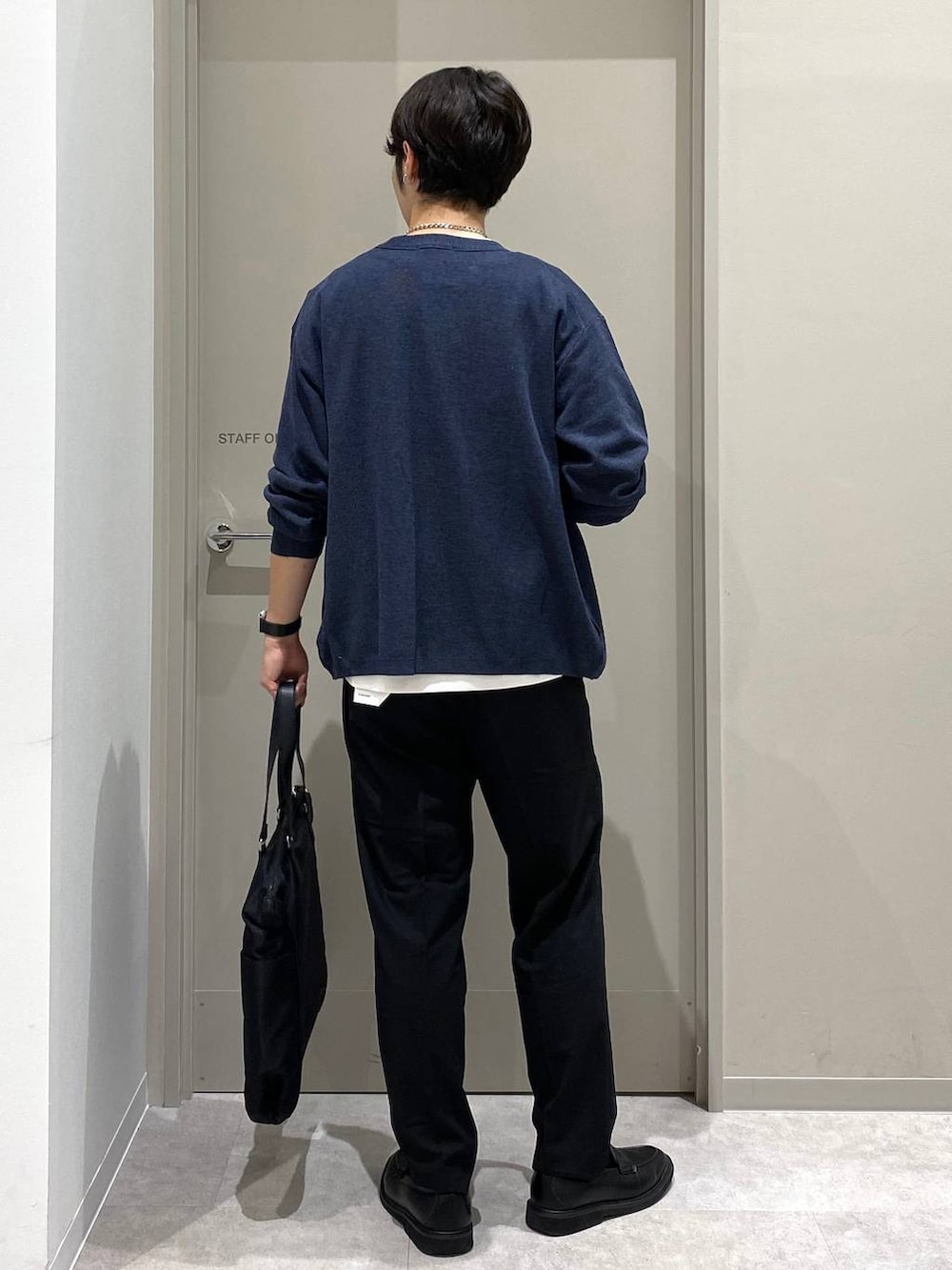 ブラック系のスラックス、ホワイト系のTシャツ/カットソー、グレー系のその他シューズを着用したメンズの秋コーディネートの3枚目の写真