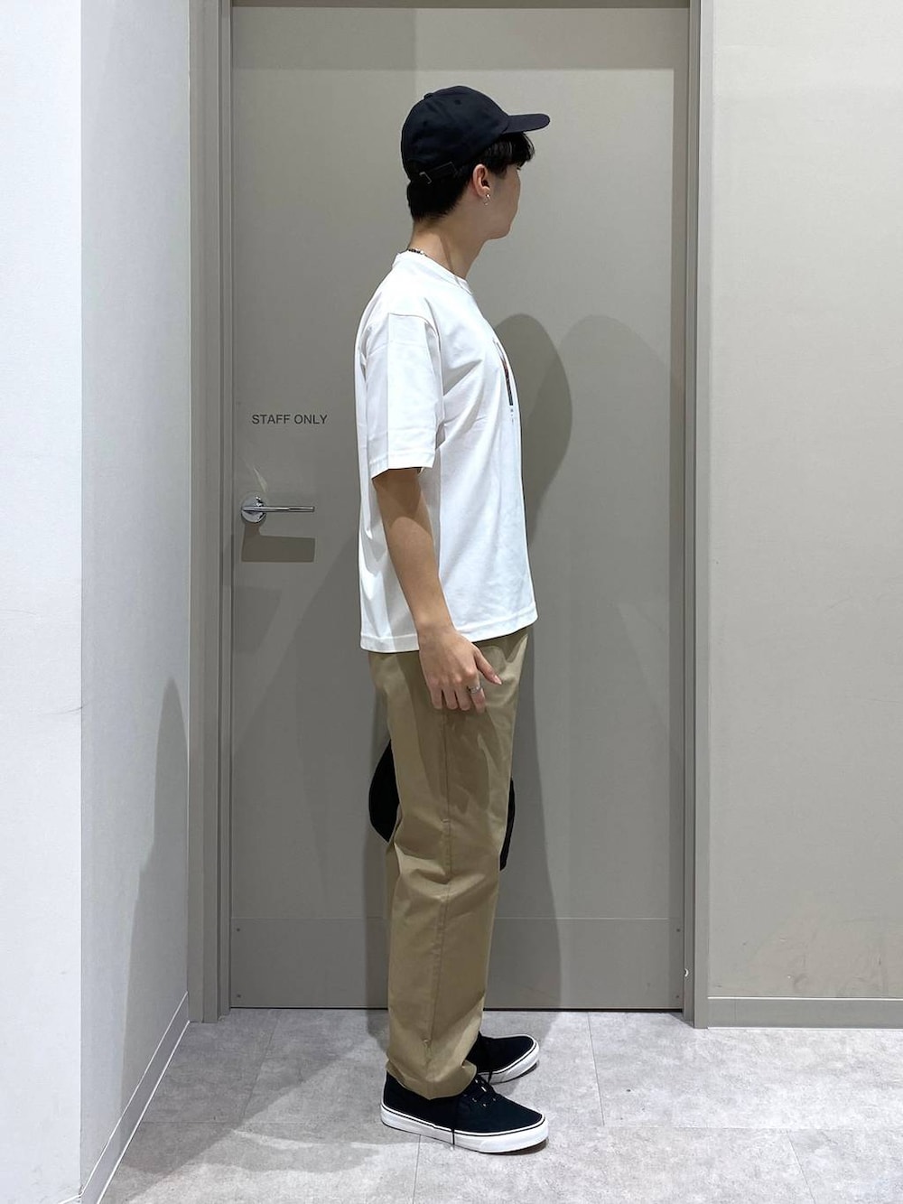 ベージュ系のその他パンツ、ホワイト系のTシャツ/カットソー、ブラック系のスニーカーを着用したメンズの夏コーディネートの2枚目の写真