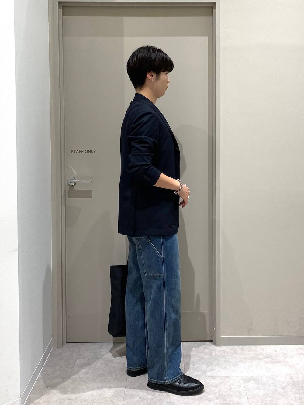 ブルー系のテーラードジャケット、ブラック系のトートバッグ、ホワイト系のTシャツ/カットソーを着用したメンズの夏コーディネートの2枚目の写真