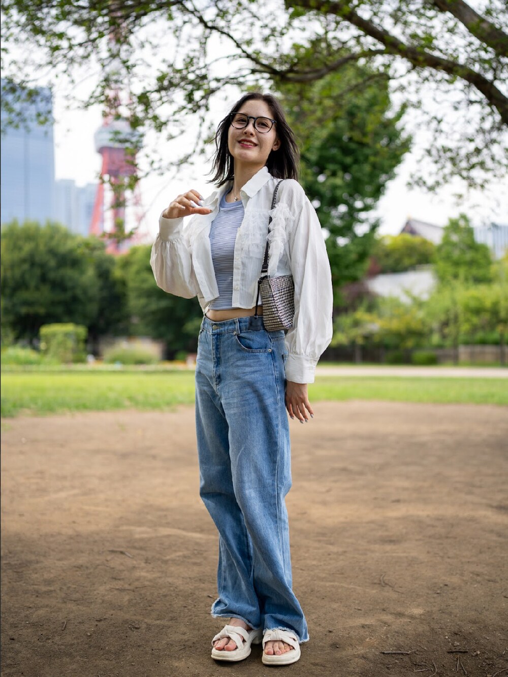 ホワイト系のトップス、ブルー系のデニムパンツ、ホワイト系のバッグを着用したレディースの秋コーディネートの2枚目の写真