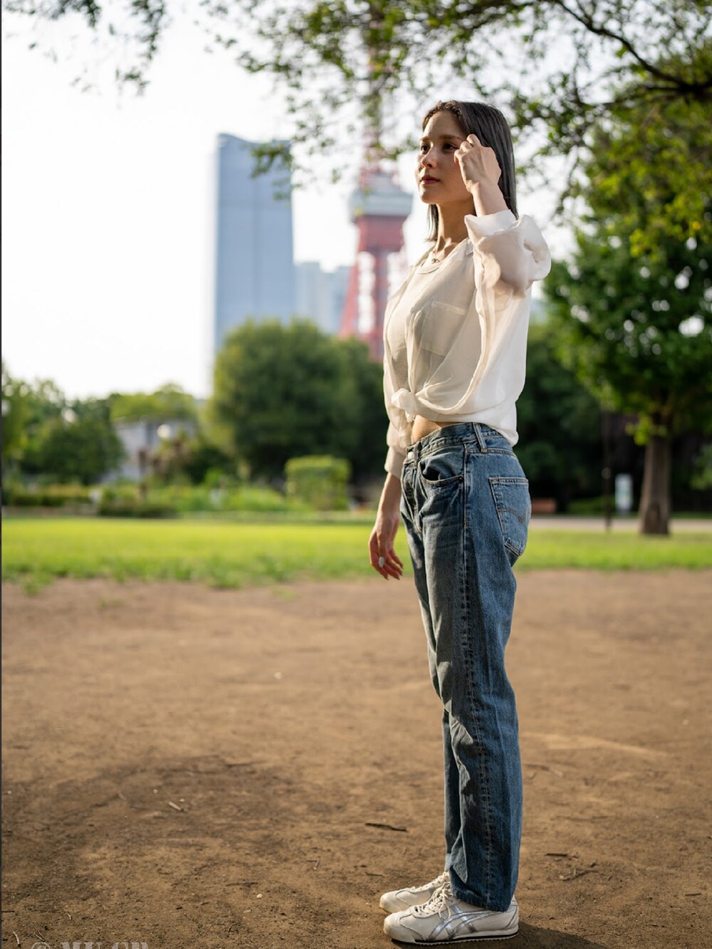 ホワイト系のシューズ、ブルー系のデニムパンツを着用したレディースの秋コーディネートの2枚目の写真