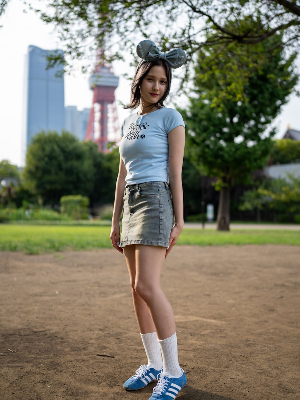 パープル系のTシャツ/カットソー、ブルー系のデニムスカート、ブルー系のスニーカーを着用したレディースの夏コーディネートの2枚目の写真