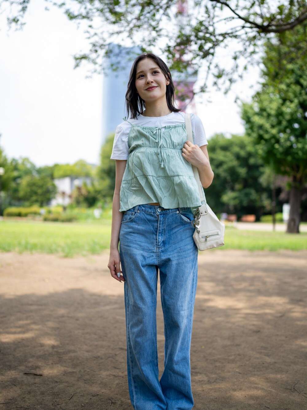 ホワイト系のシューズ、ブルー系のデニムパンツを着用したレディースの秋コーディネートの2枚目の写真