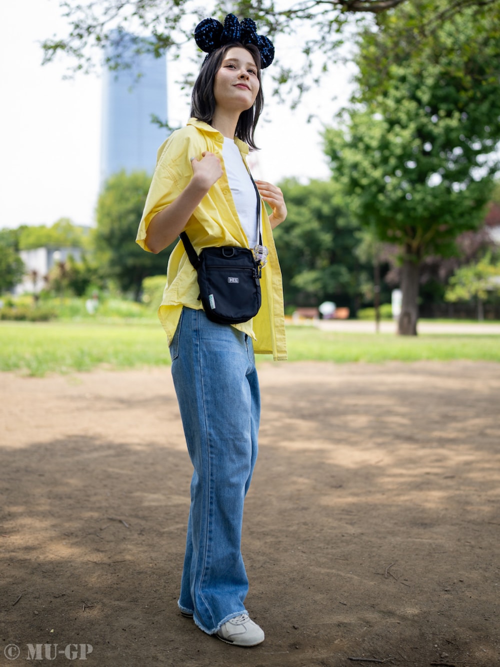 イエロー系のシャツ/ブラウス、ブラック系のショルダーバッグ、ホワイト系のスニーカーを着用したレディースの夏コーディネートの2枚目の写真