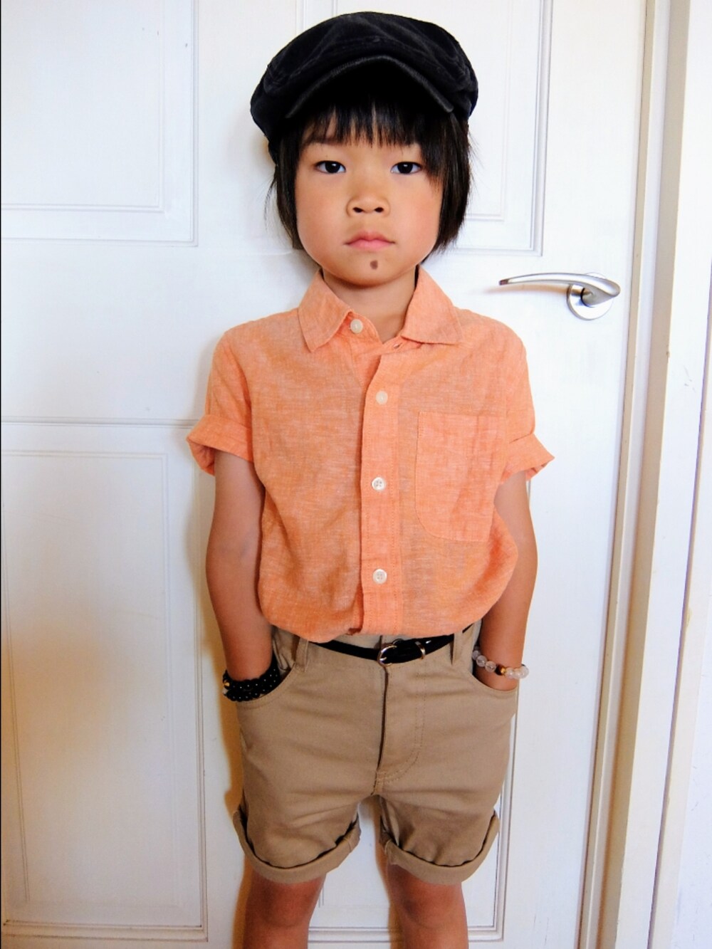 オレンジ系のシャツ/ブラウス、ブルー系のローファー、グレー系のハンチング/ベレー帽を着用したキッズの夏コーディネートの3枚目の写真