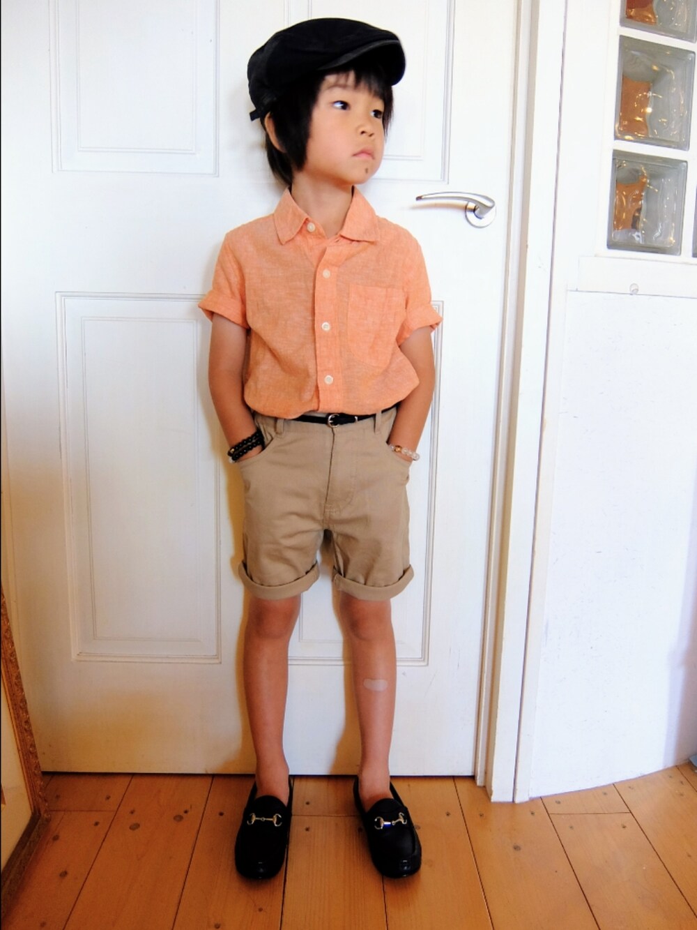 オレンジ系のシャツ/ブラウス、ブルー系のローファー、グレー系のハンチング/ベレー帽を着用したキッズの夏コーディネートの2枚目の写真