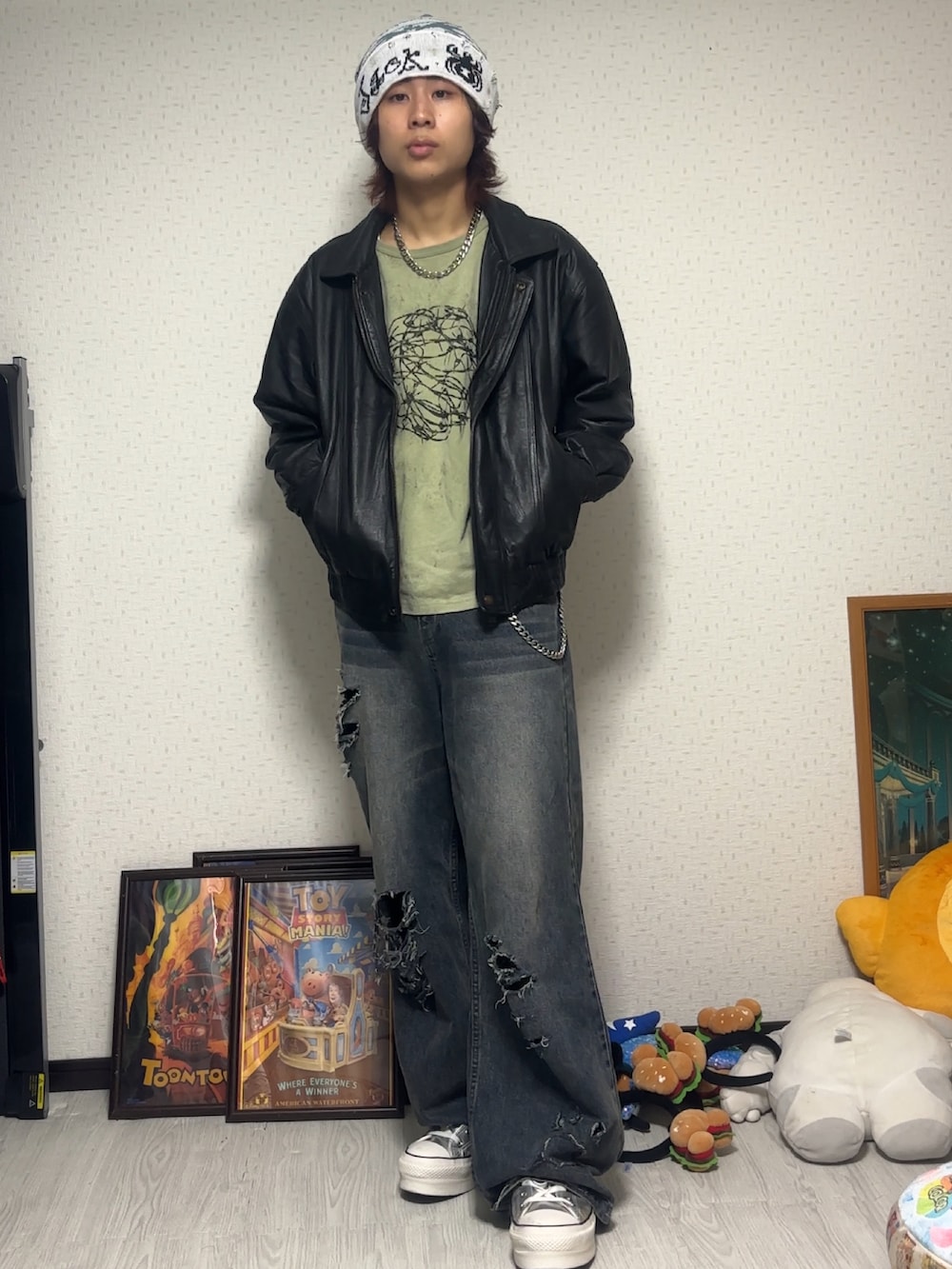 グリーン系のTシャツ/カットソー、ブルー系のデニムパンツ、シルバー系のスニーカーを着用したメンズの秋コーディネートの2枚目の写真