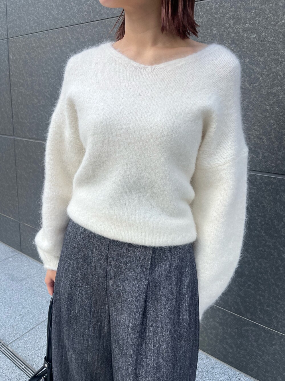 グレー系のその他パンツ、ホワイト系のニット/セーター、ブラック系のショルダーバッグを着用したレディースの冬コーディネートの5枚目の写真