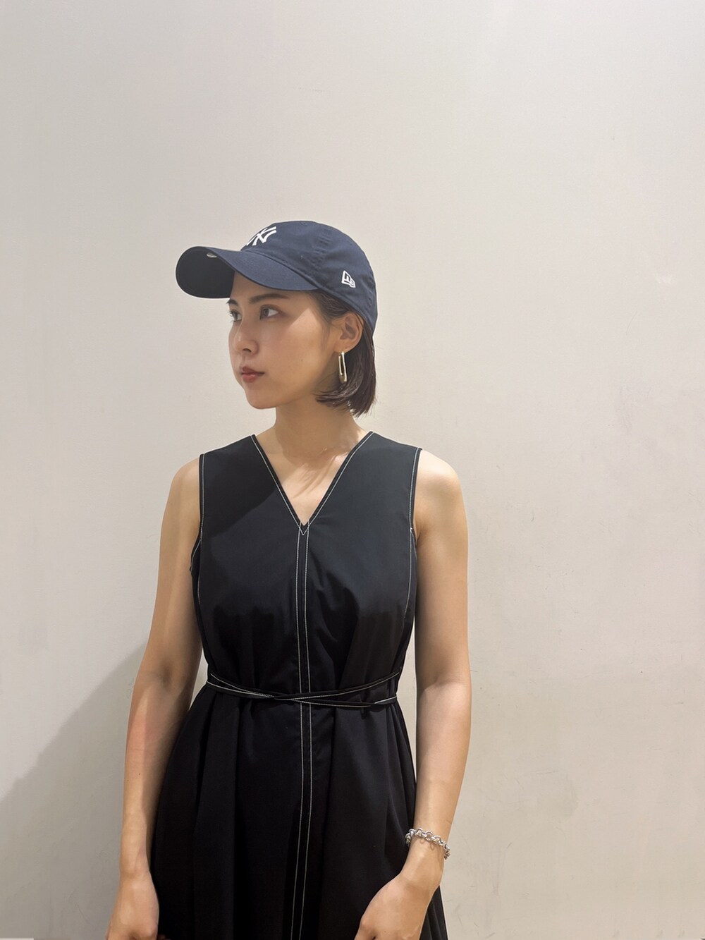 ベージュ系のハンドバッグ、ブラック系のワンピースを着用したレディースの夏コーディネートの4枚目の写真