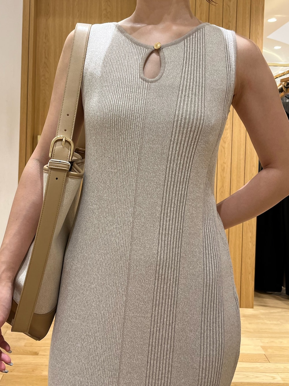 ベージュ系のワンピース、ホワイト系のスニーカー、ブラウン系のショルダーバッグを着用したレディースの夏コーディネートの4枚目の写真