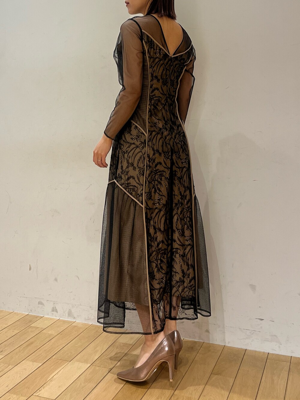 ゴールド系のパンプス、ブラック系のドレスを着用したレディースの冬コーディネートの3枚目の写真