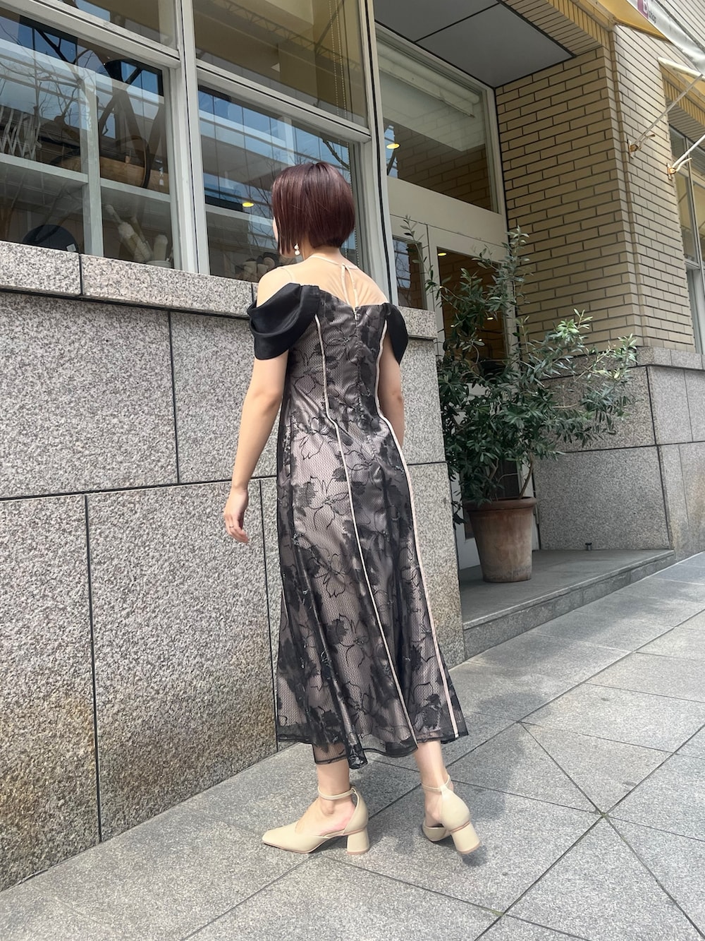 ベージュ系のパンプス、ベージュ系のハンドバッグ、ブラック系のドレスを着用したレディースの春コーディネートの2枚目の写真